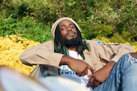 a man with dreadlocks sitting on a bench